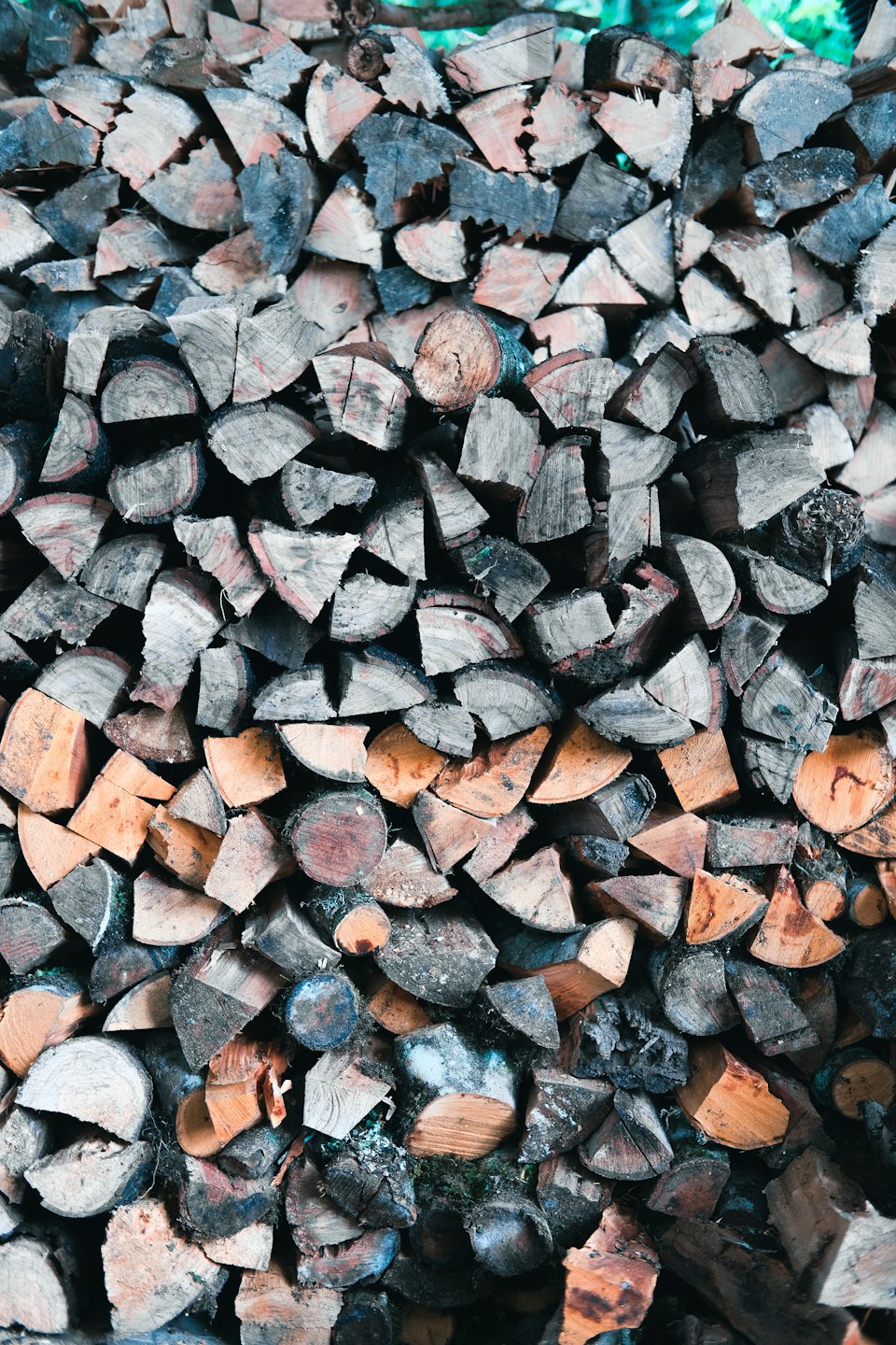 Neatly stacked pile of split firewood logs.